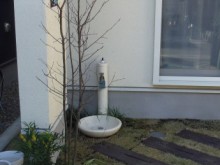 白い建物にマッチした白い立水栓　枕木と芝の水まわりもナチュラルな雰囲気が出ています