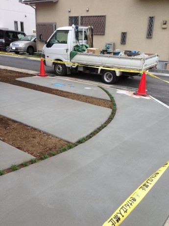 カーブのスリットにタマリュウを植えてきれいなラインが駐車場に描かれました